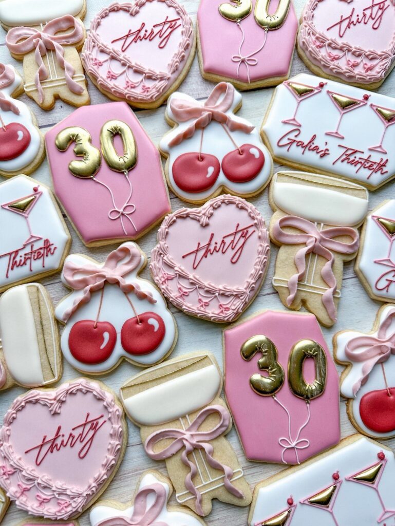 Decorated pink and white sugar cookies celebrating a 30th birthday with gold accents