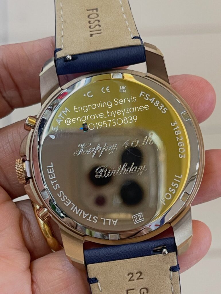 Gold Fossil wristwatch back engraved with Happy 40th Birthday held in a hand