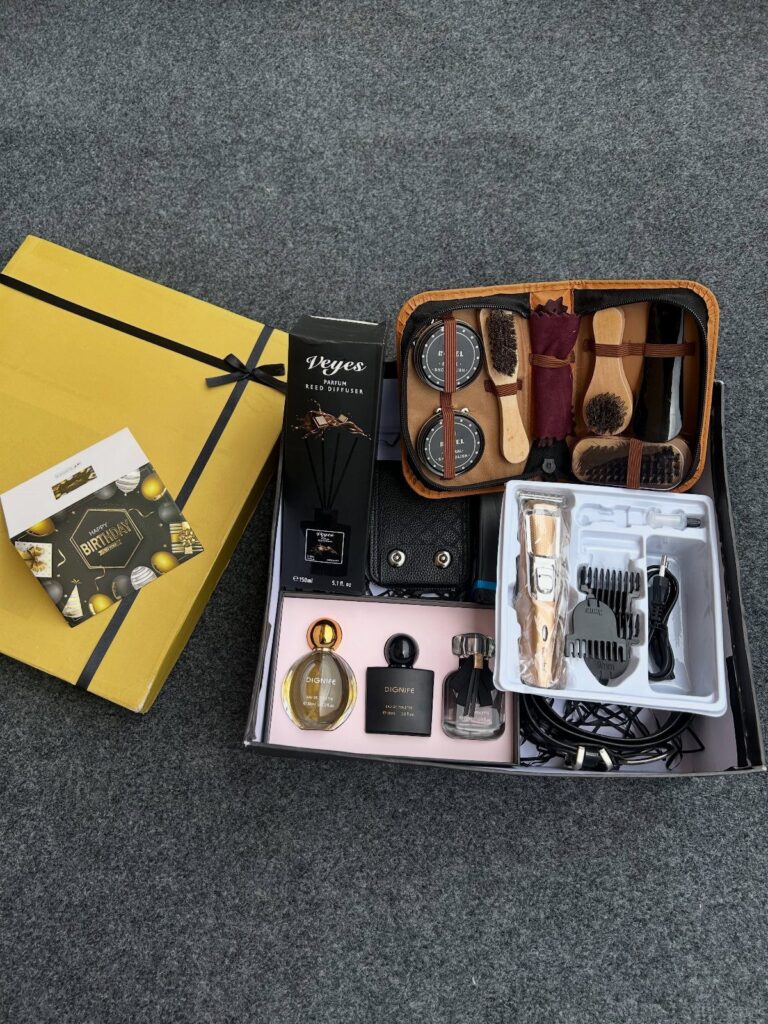 Men's grooming kit with electric clipper, cologne bottles, and brushes in leather case.