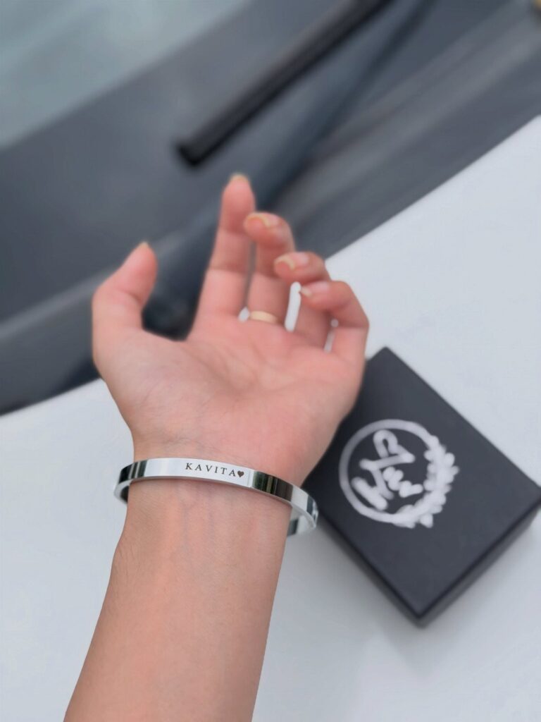 Silver cuff bracelet engraved with the name Kavita and a heart on wrist